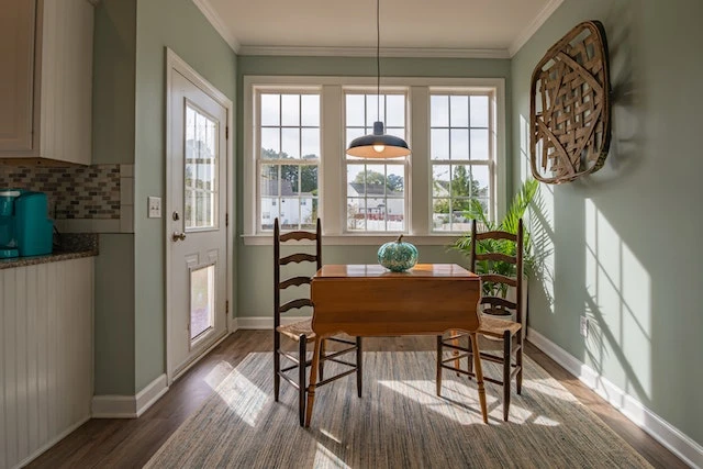 a bright kitchen with a brown wooden table in front of windows