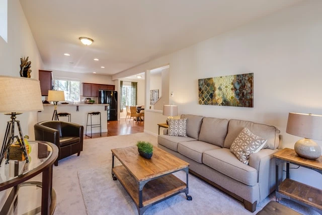 a contemporary living room with a tan couch and a wooden coffee table