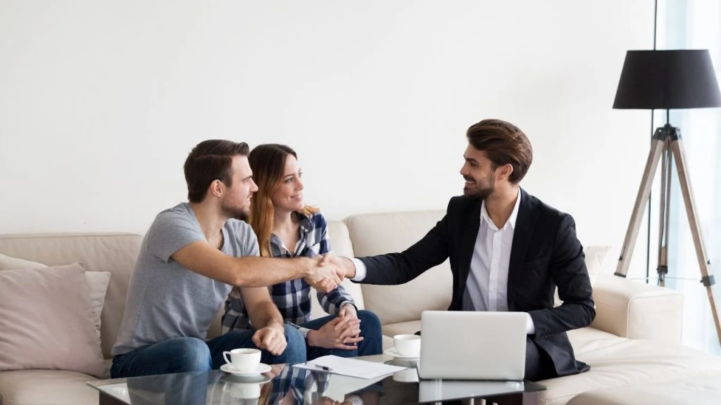 A couple and their property manager sitting on a couch