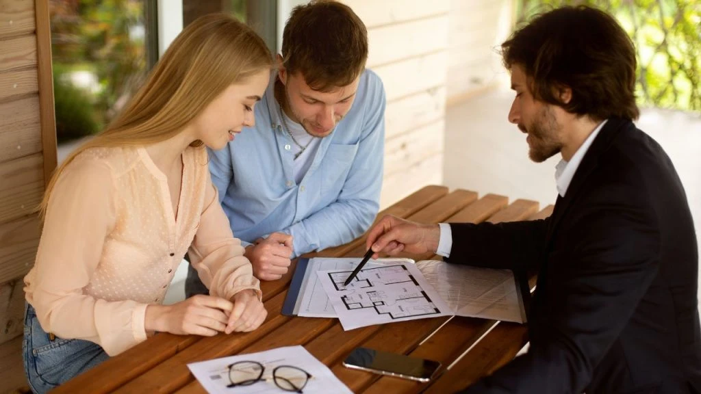 A couple looking over a document with a leasing consultant wearing a suit