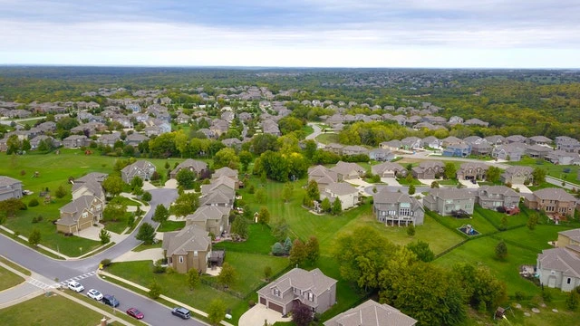 Birds-eye-view-of-a-neighborhood-with-lots-of-houses-and-green-space