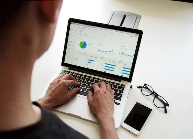 Photo of a person from behind who is looking at their laptop