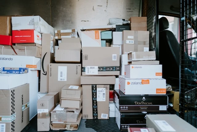 The back of a mail van full of stacked boxes and packages