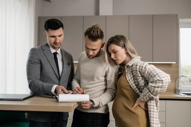 Couple looking at a document in their kitchen with their property manager