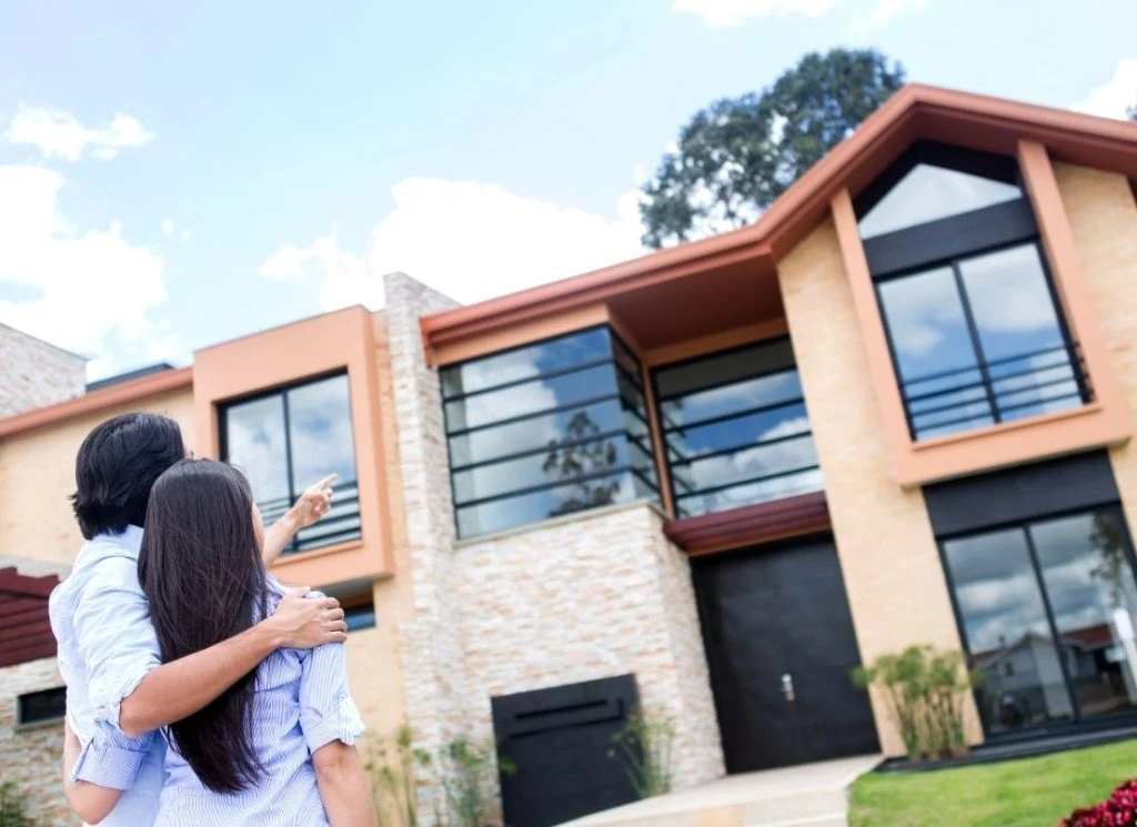 Couple looking at the exterior of a single-family home