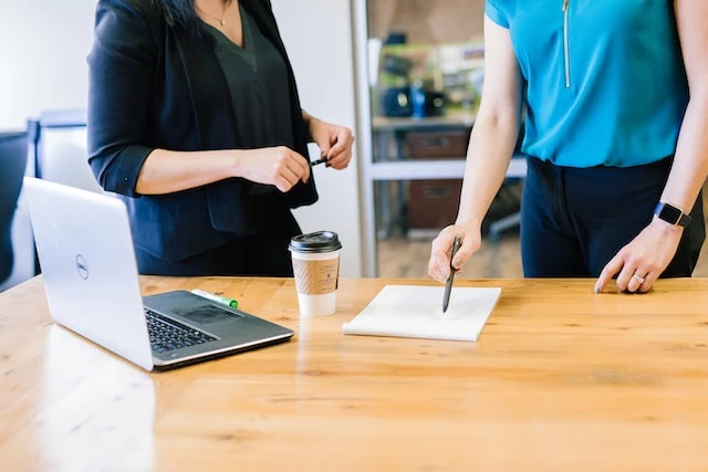 Cropped image of two people looking at a document on a table