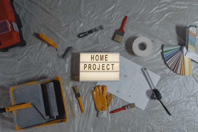 Floor covered in tools with a sign that says HOME PROJECT