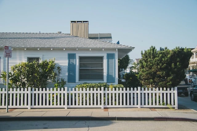 Exterior of a small white house with blue shutters