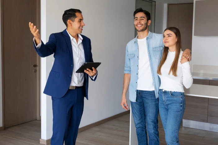 Agent showing a property to a young couple during a walkthrough