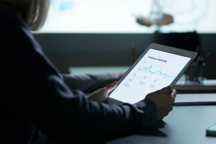 Close up of a person looking at graphs on a tablet screen