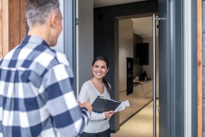 Agent welcoming a visitor at the door during an open house showing