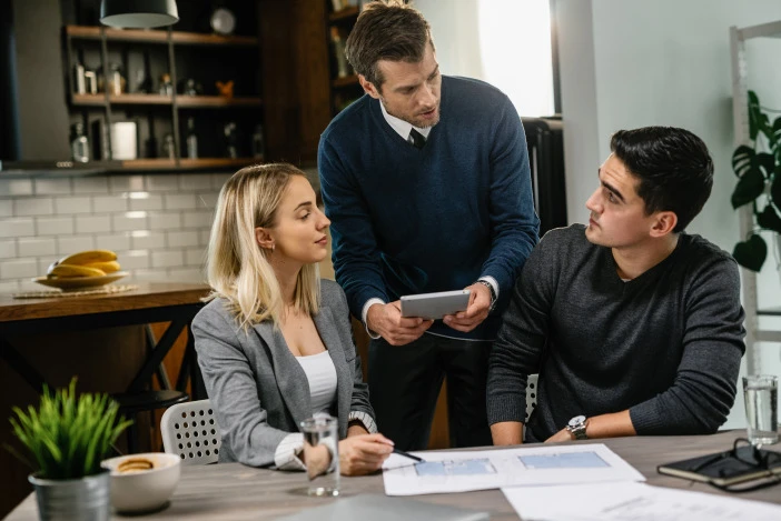 Property manager discussing market charts with owner clients at a table