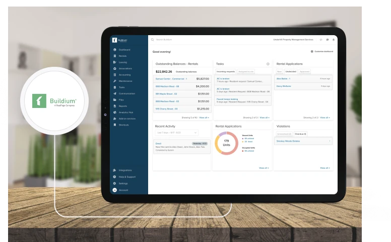 Buildium property management dashboard shown on a tablet, displaying balances, tasks, and rental applications