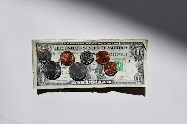One dollar bill with coins on it