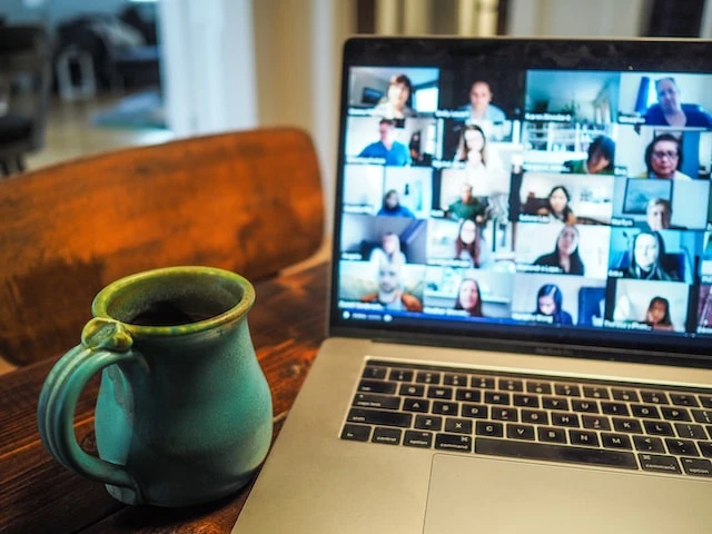 Laptop computer open to a virtual meeting with 20 property managers
