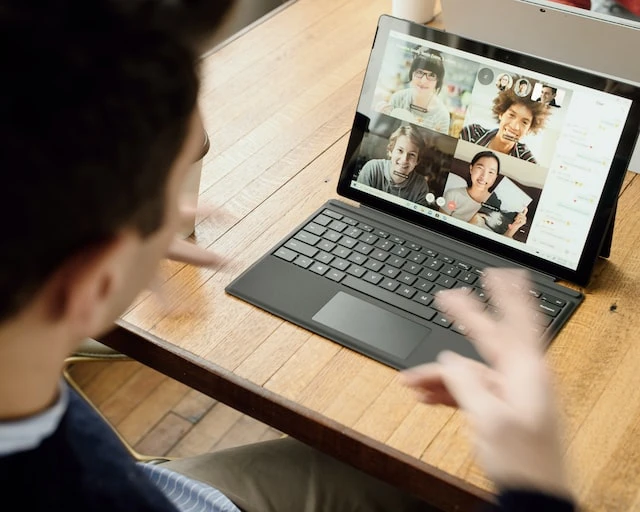 Property manager looking at their laptop while having a video call with 4 other people