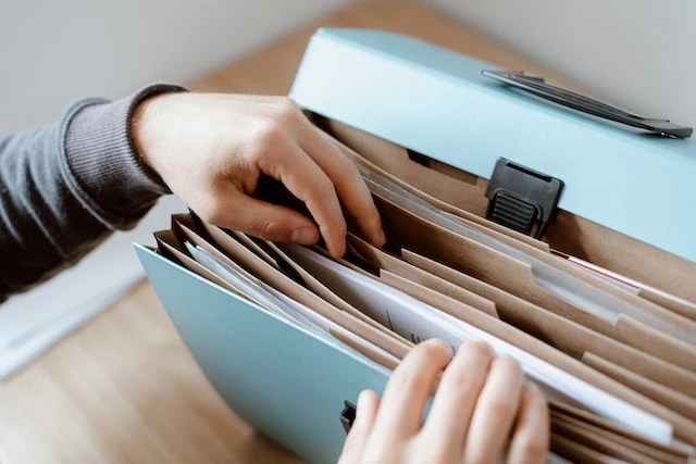 Person looking through documents in a file folder