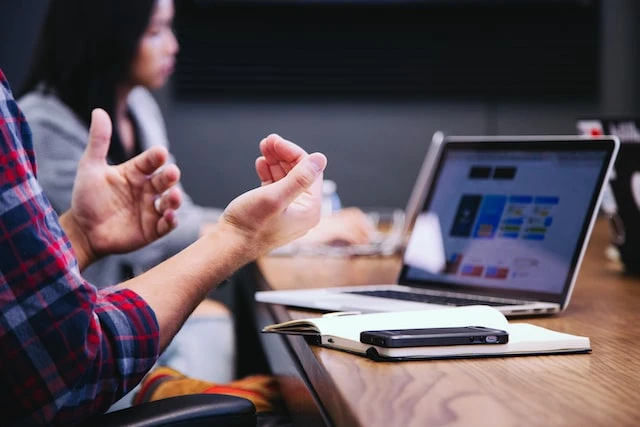 A property manager talking about something on their laptop to a group of people in a conference room