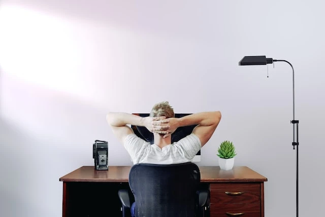 Property manager with their hands behind their head sitting at a desk