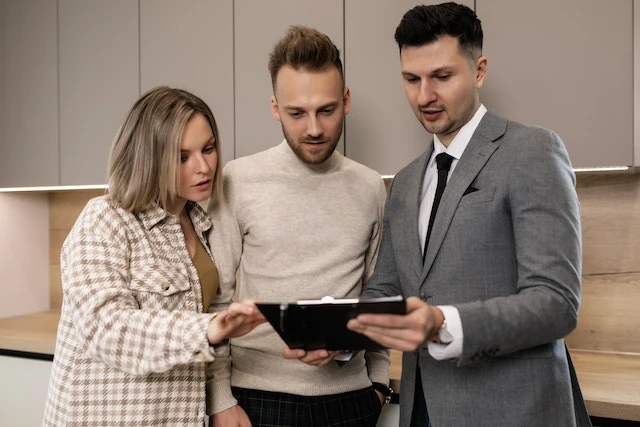 Real estate agent showing a notepad to two people