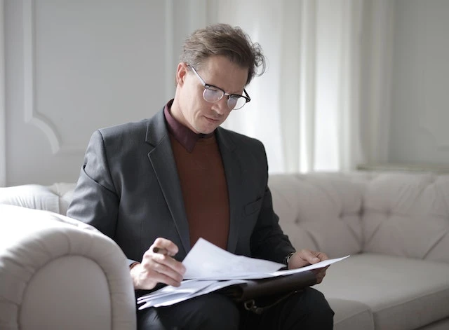 A lawyer sitting on a couch reviewing documents