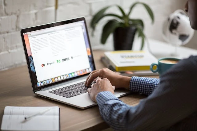 Person using a macbook at their desk