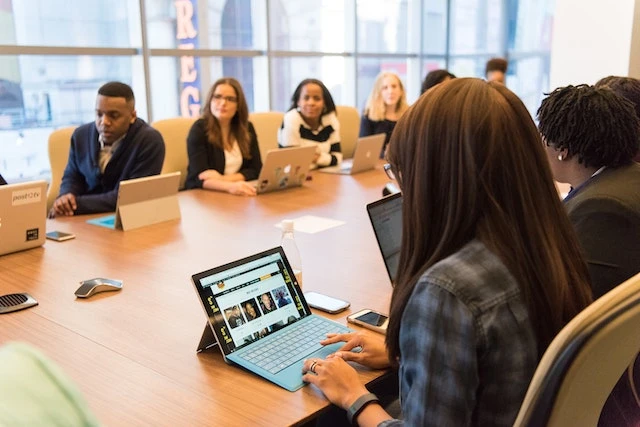 Group of property managers sitting around a conference table with their laptops