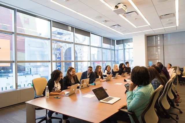 A large group of people sitting at a conference table together