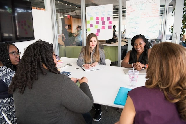 A five person property management team sitting at a table in an office