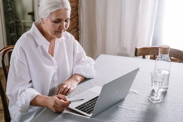 Person sitting at a table using their laptop