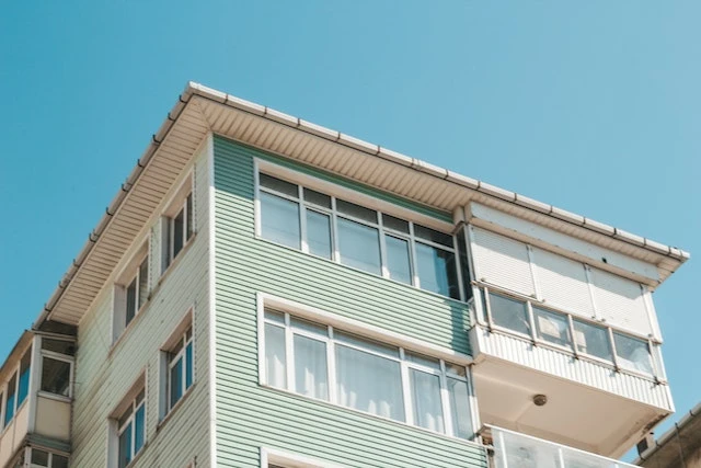 Exterior shot of the top two floors of a green and white building