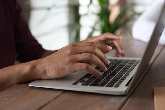 Close up of hands typing on a laptop