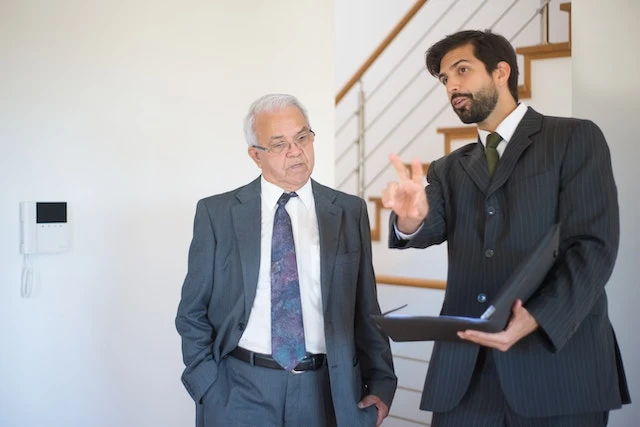 Two people in suits standing next to each other