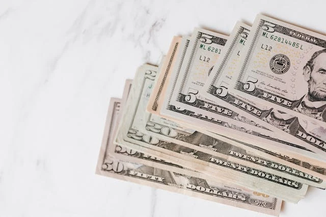 US dollars bills in a stack being used for money paid as a security deposit