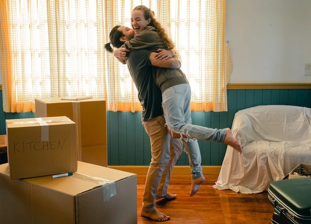 Happy couple next to moving boxes