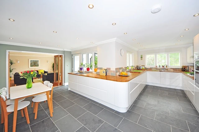 Interior of a white kitchen with grey slate floors