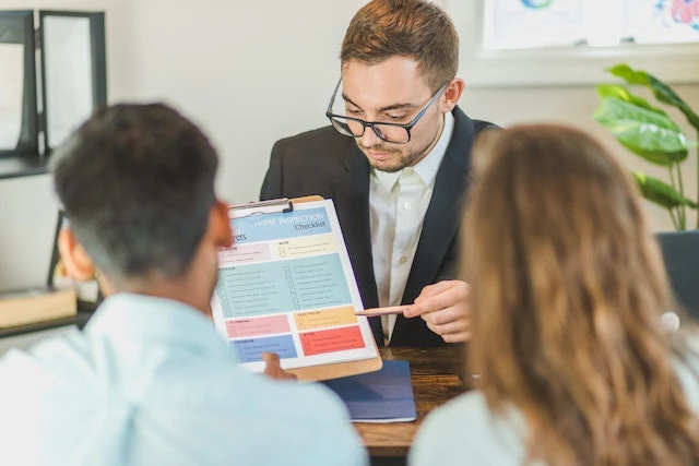 Real estate agent explaining a colorful document to two clients
