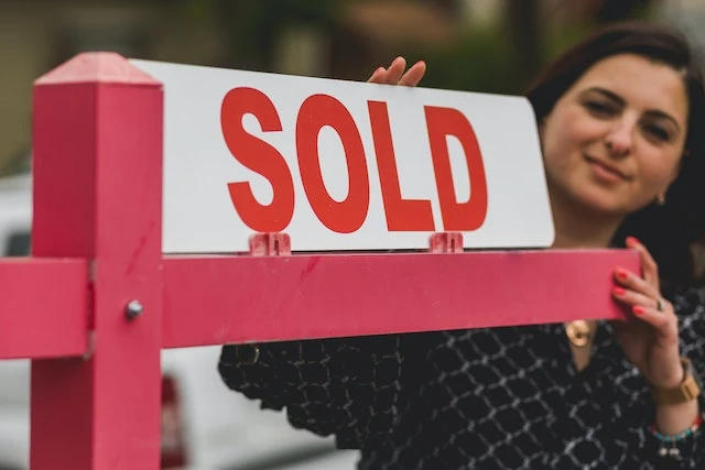 Person putting up a sold sign