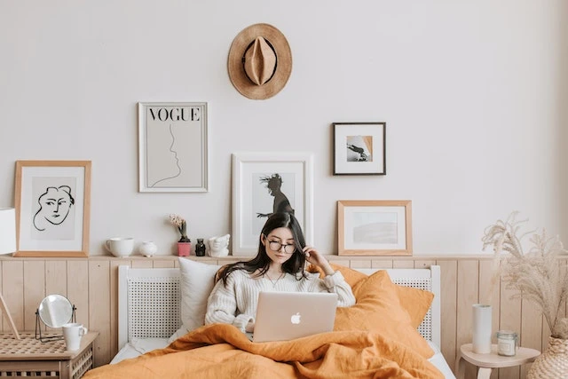 A property manager working on her laptop in her bed