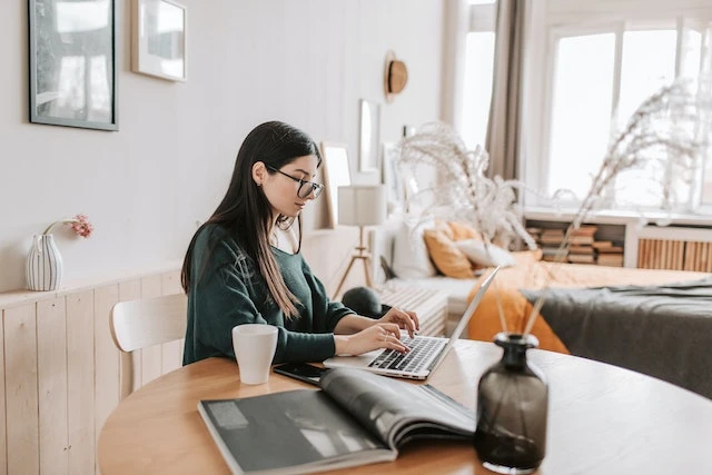 Young property manager working on her laptop at a wooden table