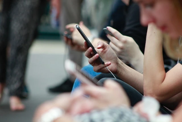 A row of people using their smartphones