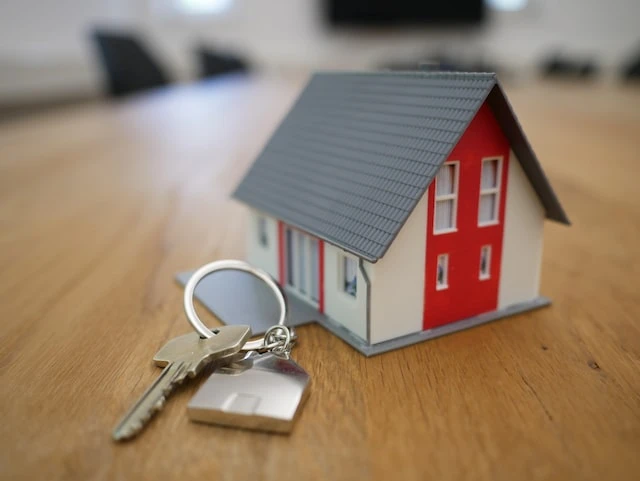 Small replica of a white and red hour next to a set of keys