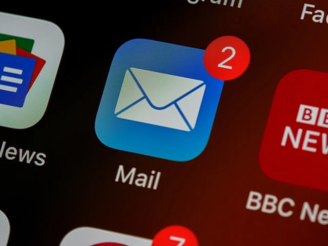 The white and blue mail app with two notifications on an iPhone screen