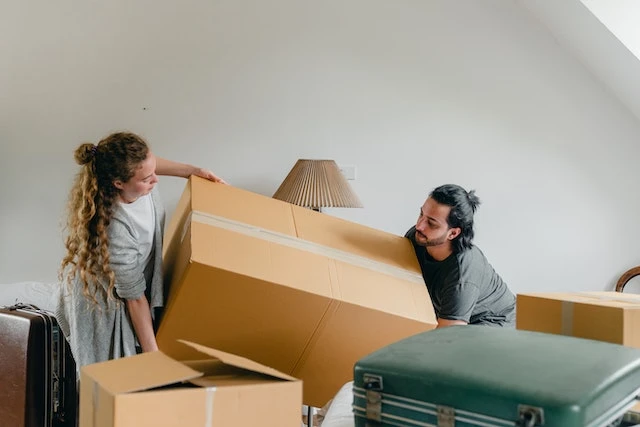 two people lifting a large box