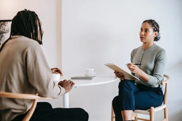 two people sitting at a table in an interview
