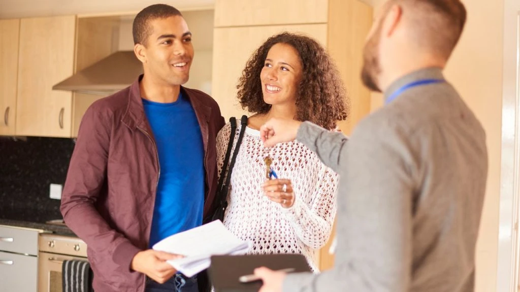 Two people talking to a third person in a suit 