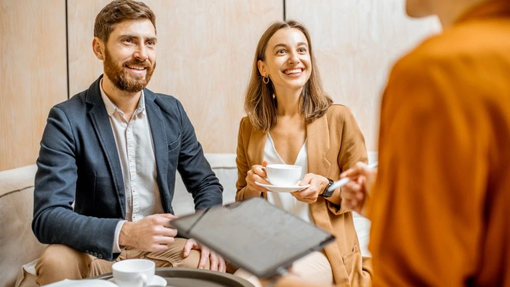 Two smiling people looking over a document from two separate property management company