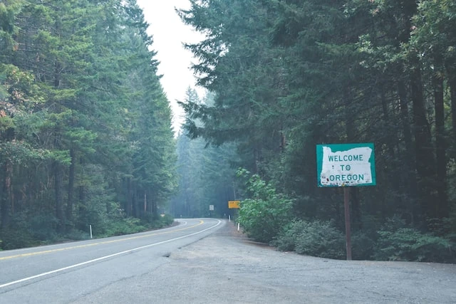 Welcome to Oregon sign on the side of a forest road