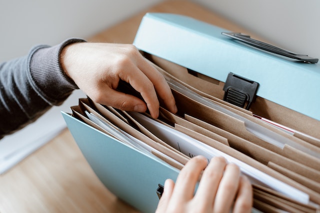 Person looking through documents in a file folder