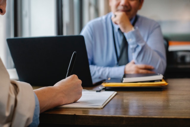 Close up of two people sitting across from each other at a desk